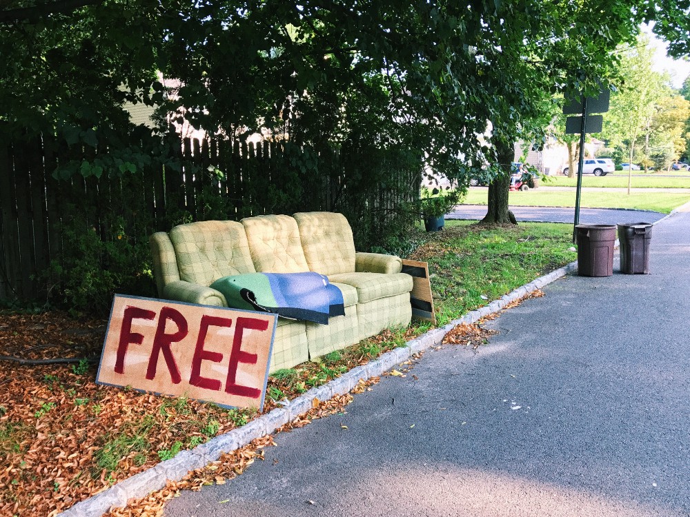 Photo of discarded couch with sign that says "Free"