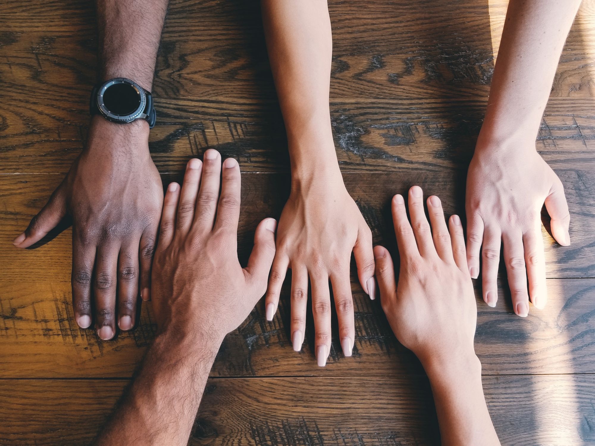 Assortment of hands laid on a wooden table