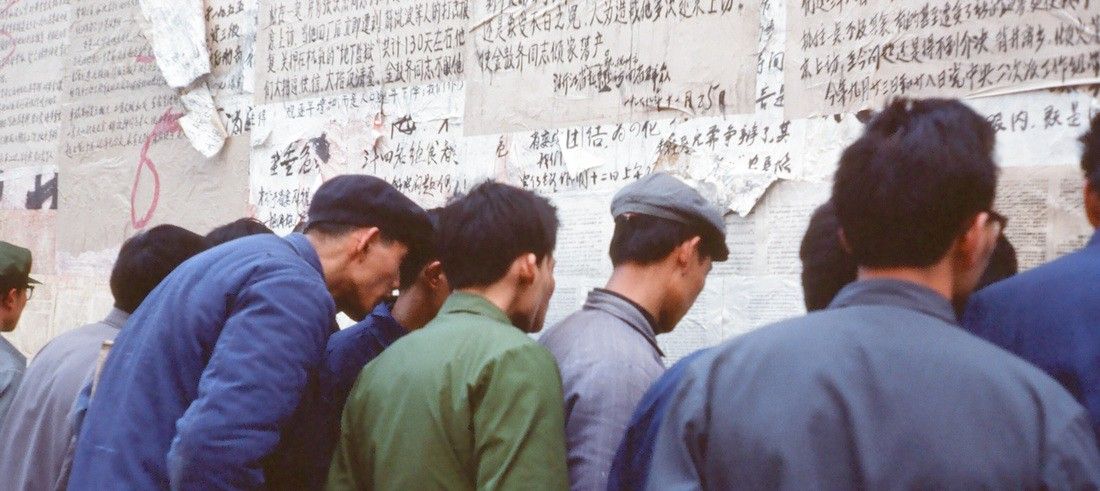 Photo of men looking at wall of writing